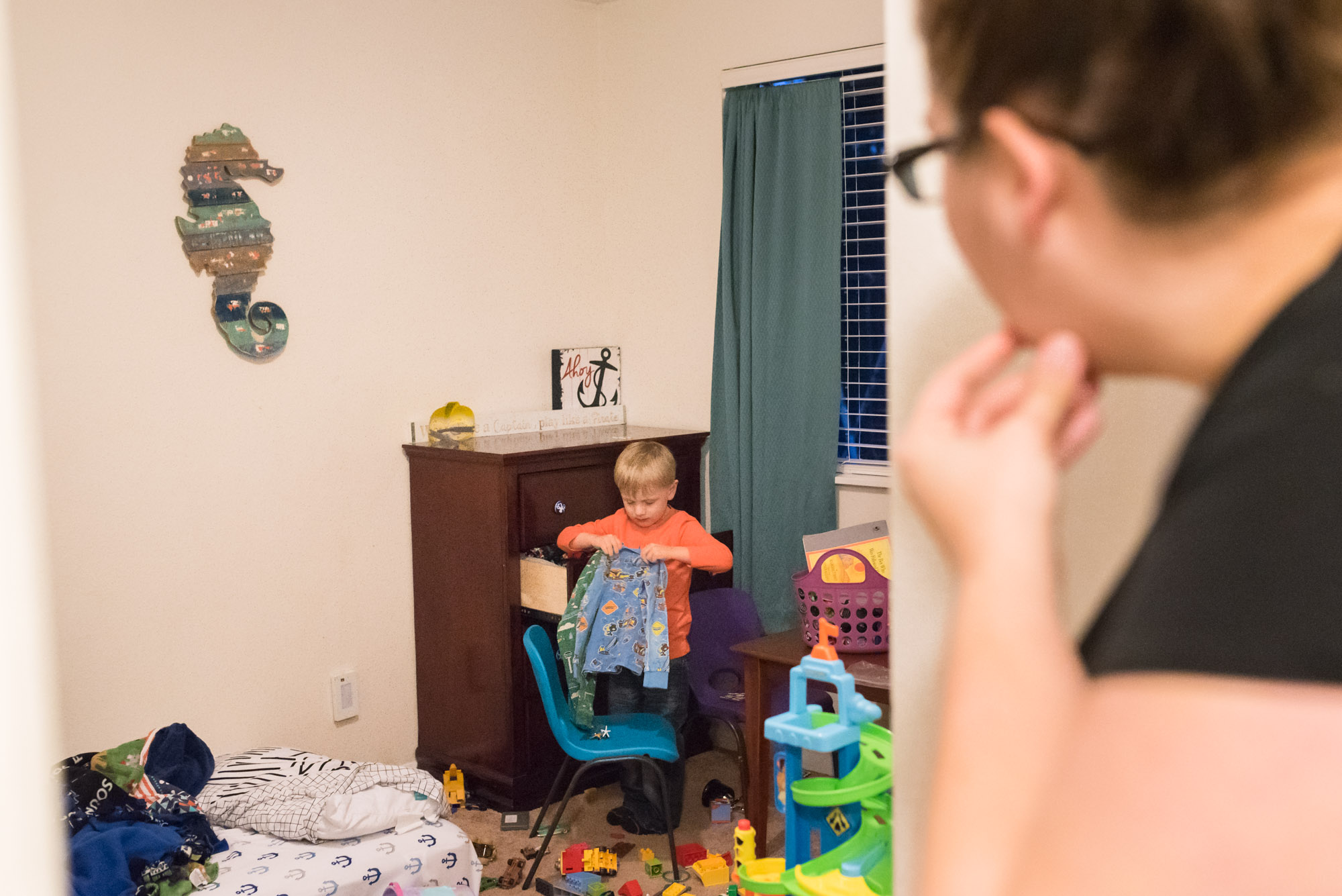 boy picks out mis matching pajamas - documentary photography military families