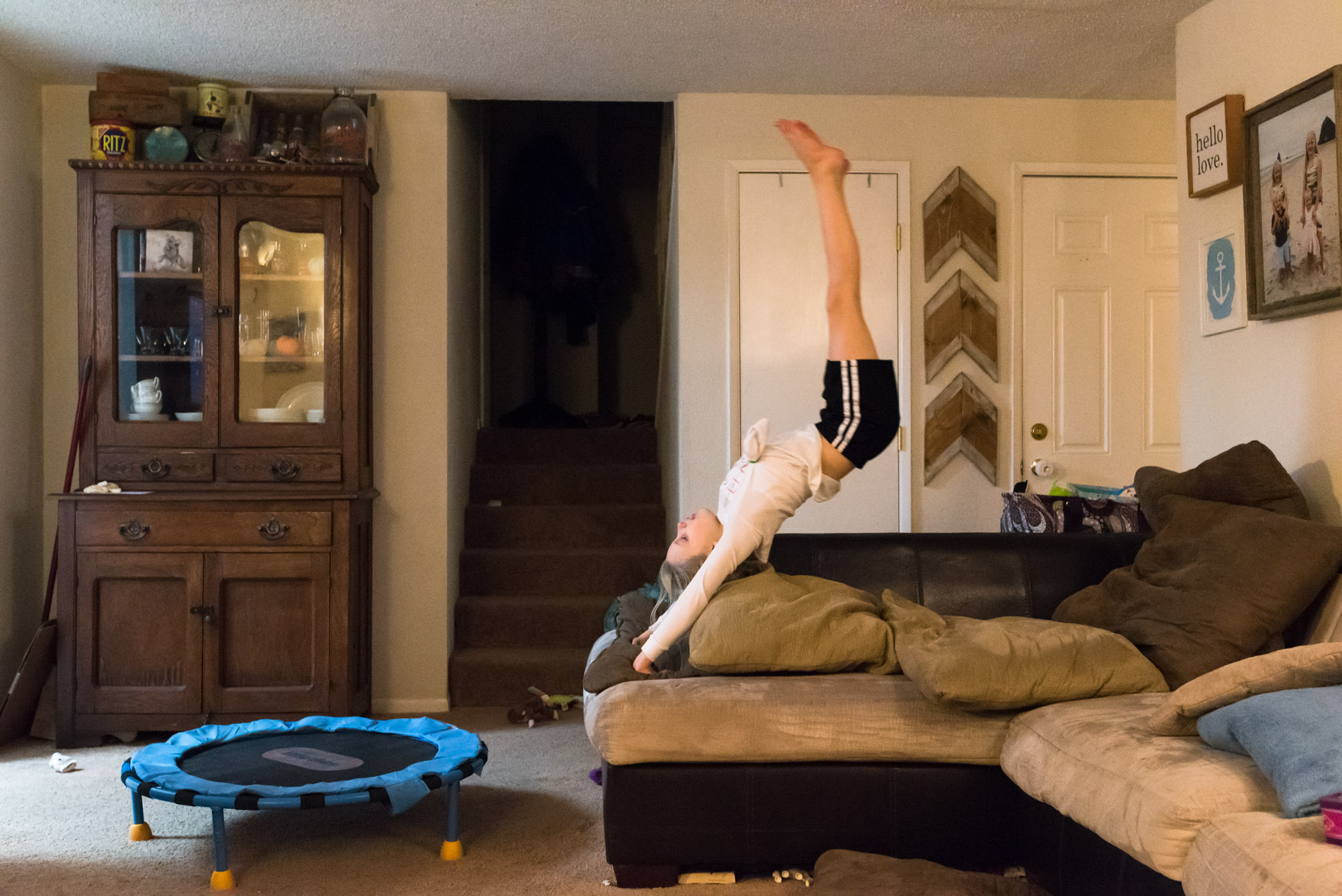 girl practices flips on couch - documentary photography military families