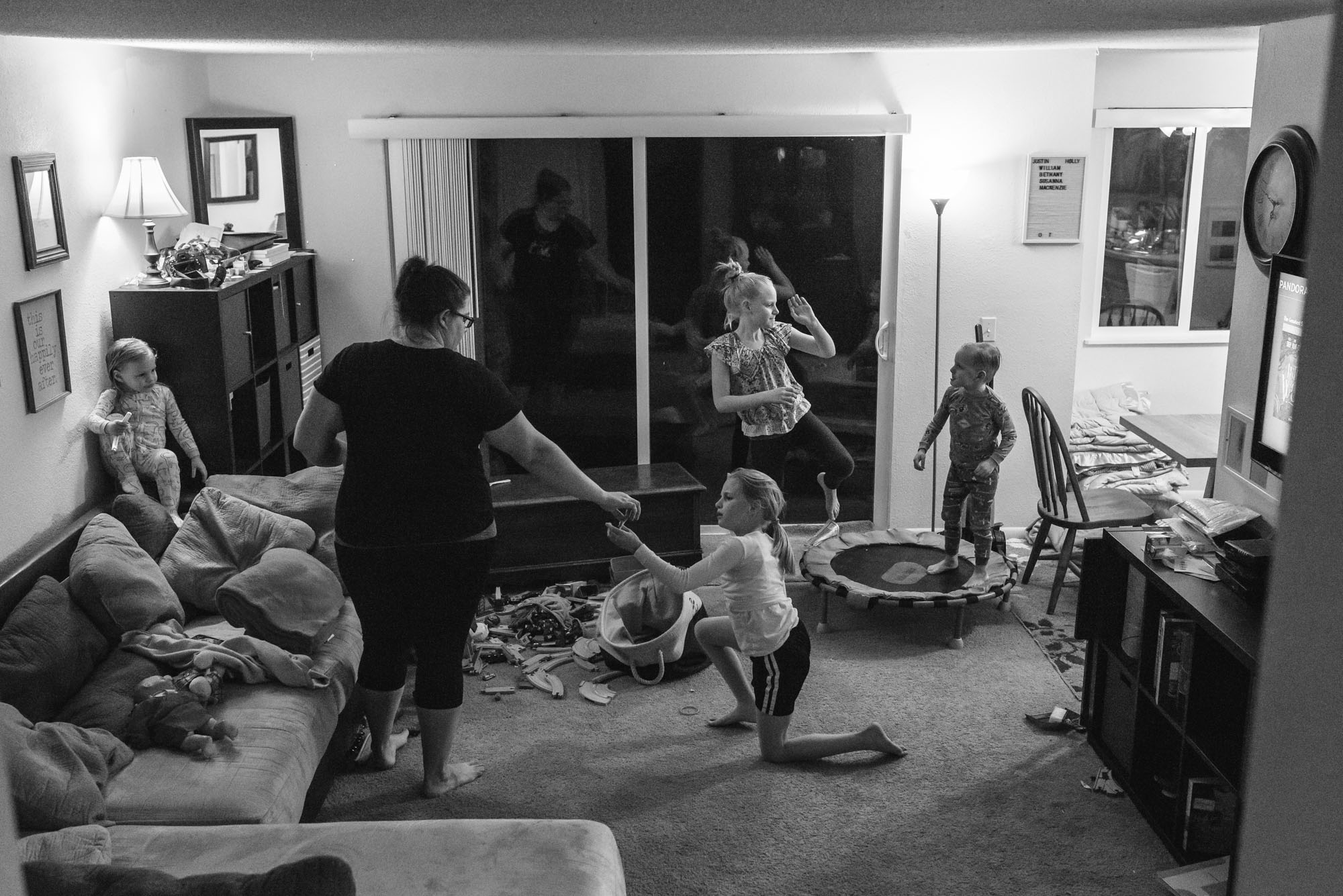 family rallies to clean up living room before bedtime - documentary photography military families
