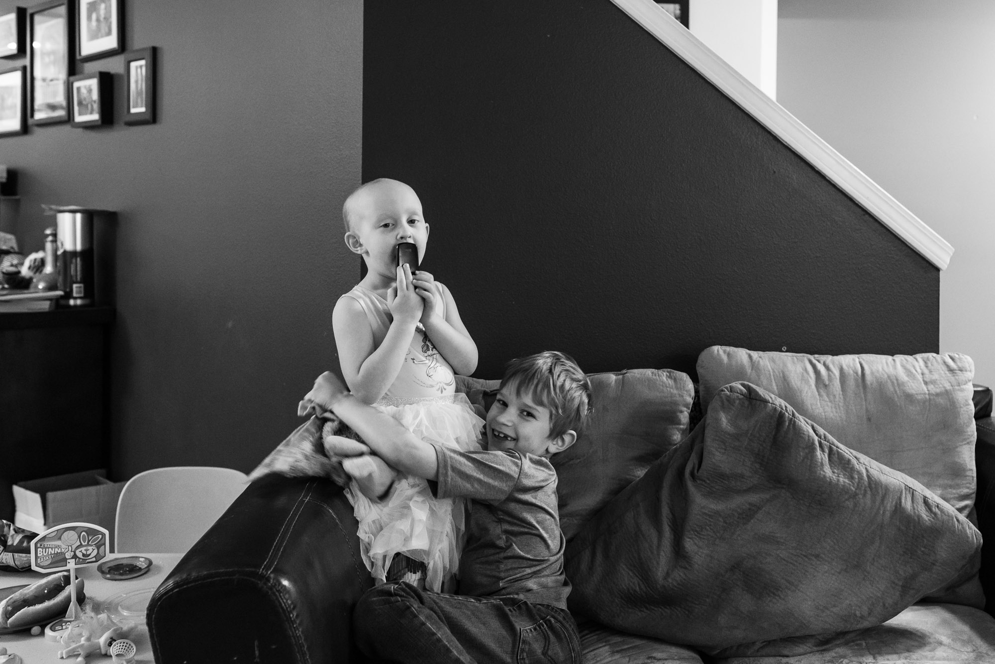 brother hugs sister on couch - documentary photography of military families
