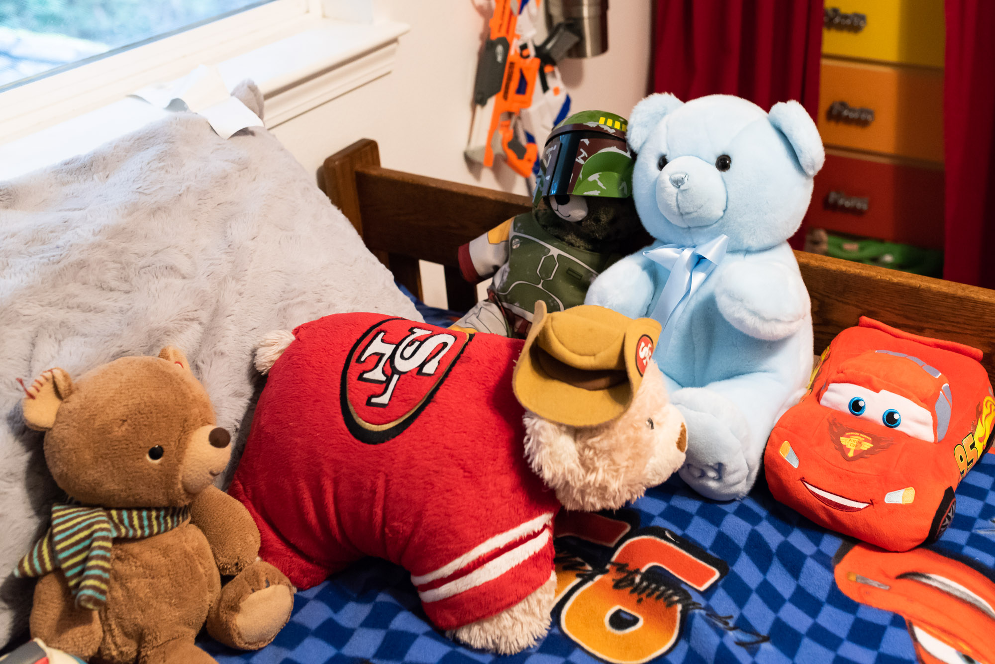 stuffed animals on boy's bed - documentary photography of military families