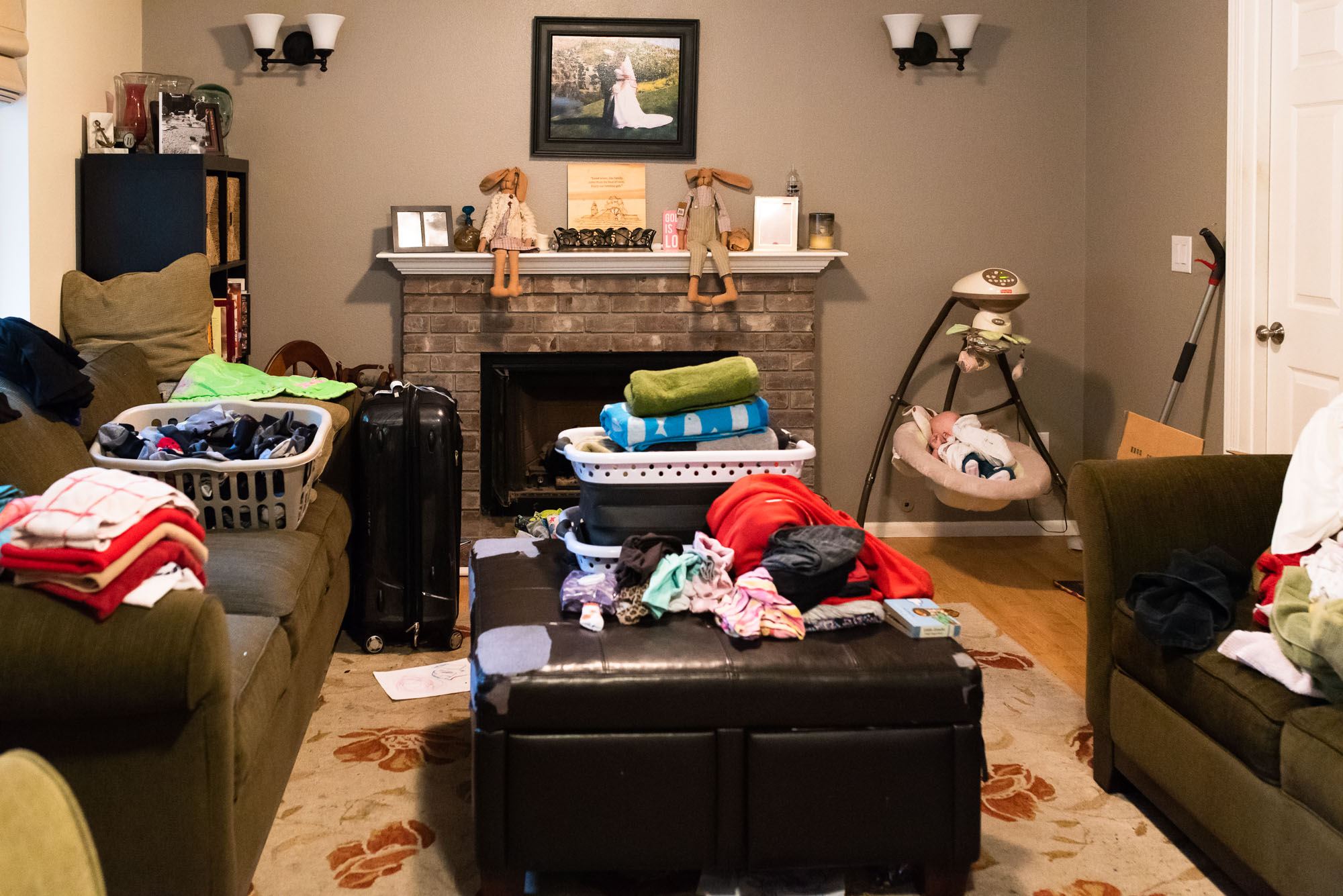 baby asleep in swing amongst laundry - documentary photography of military families