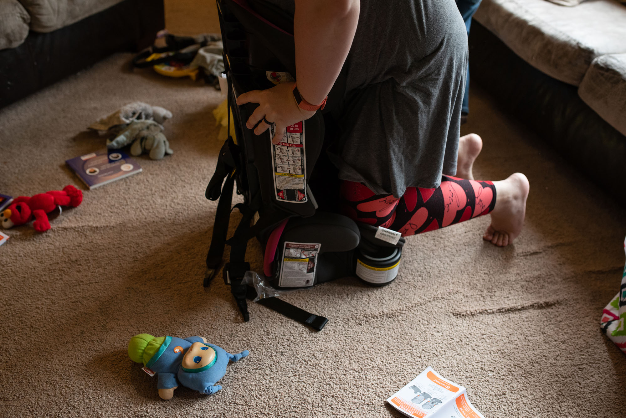 mother forcefully assembles car seat - documentary photography of military families
