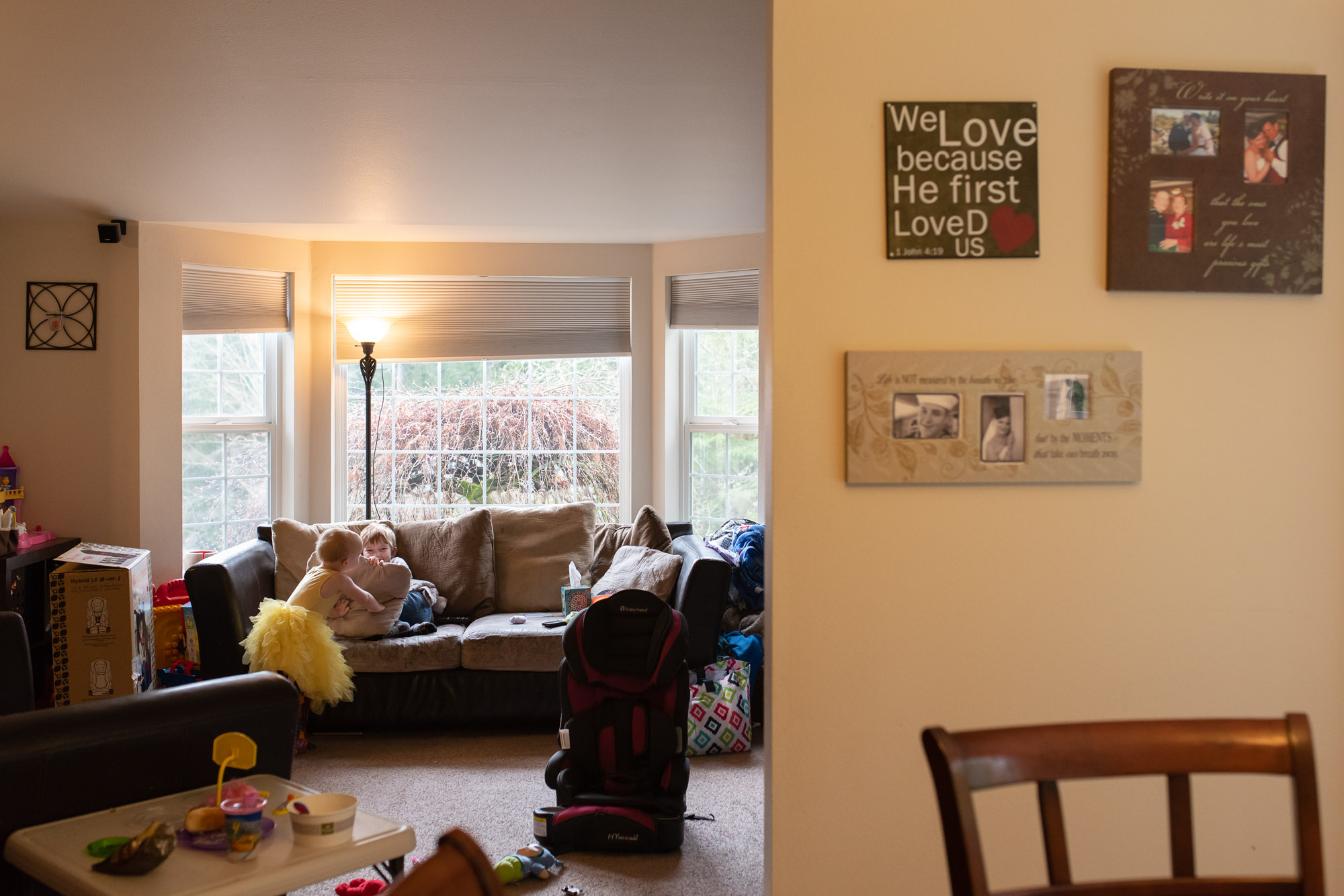 brother and sister tackle each other on couch - documentary photography of military families