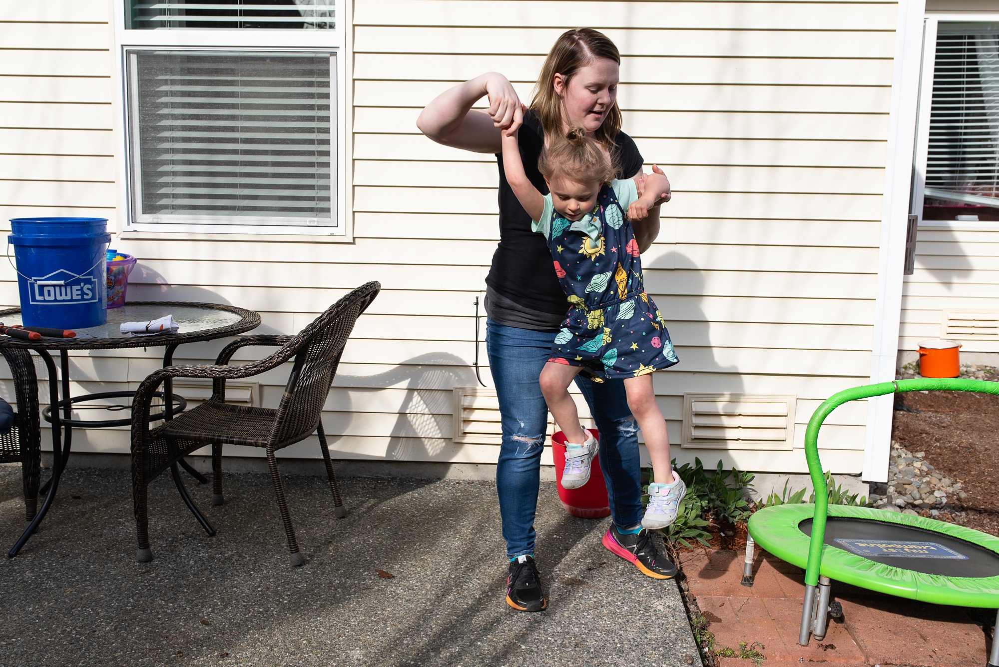 mom helps daughter off mini trampoline