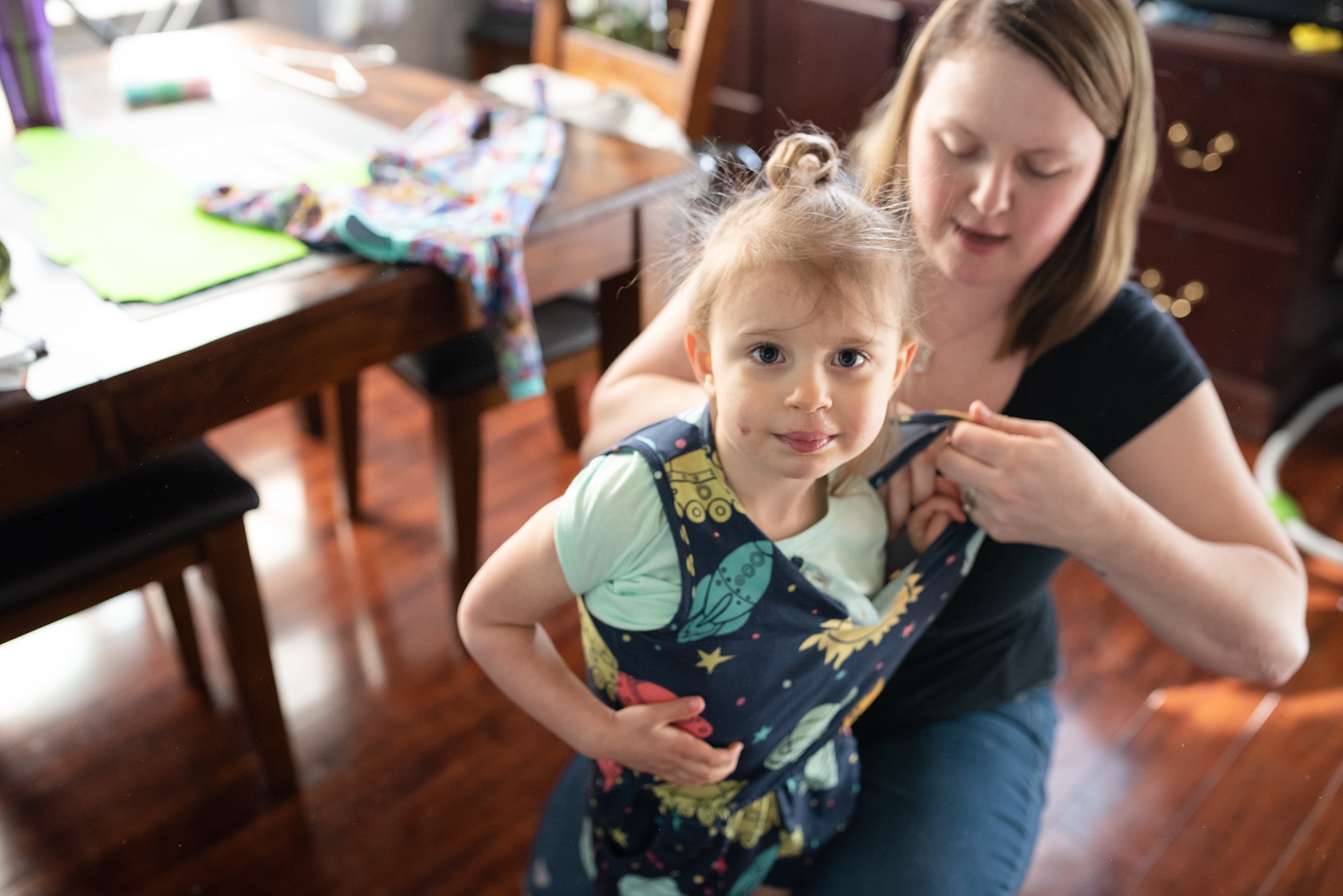 mom helps daughter with jumper