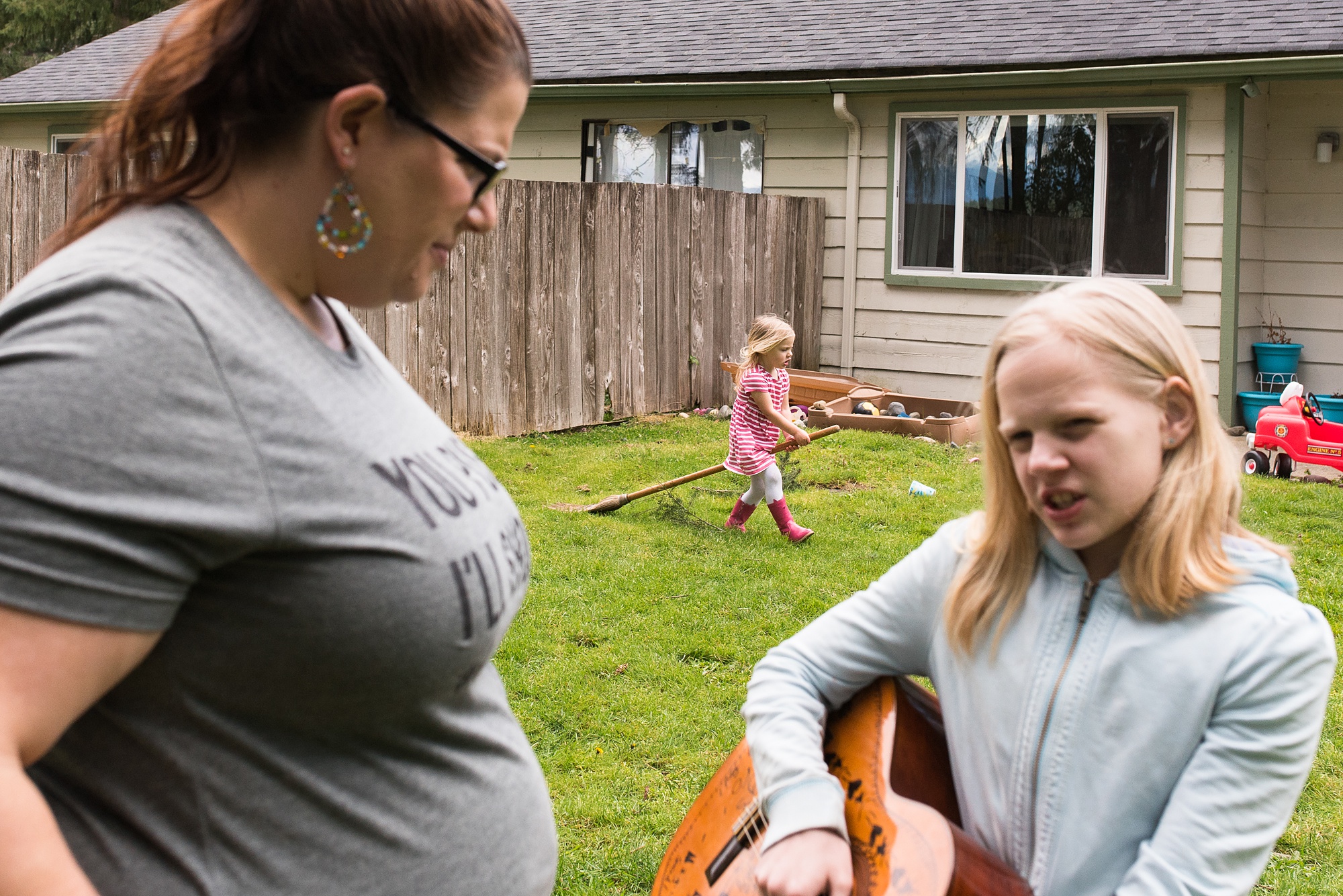 mom and daughter talk while youngest child plays in back ground - military family photography