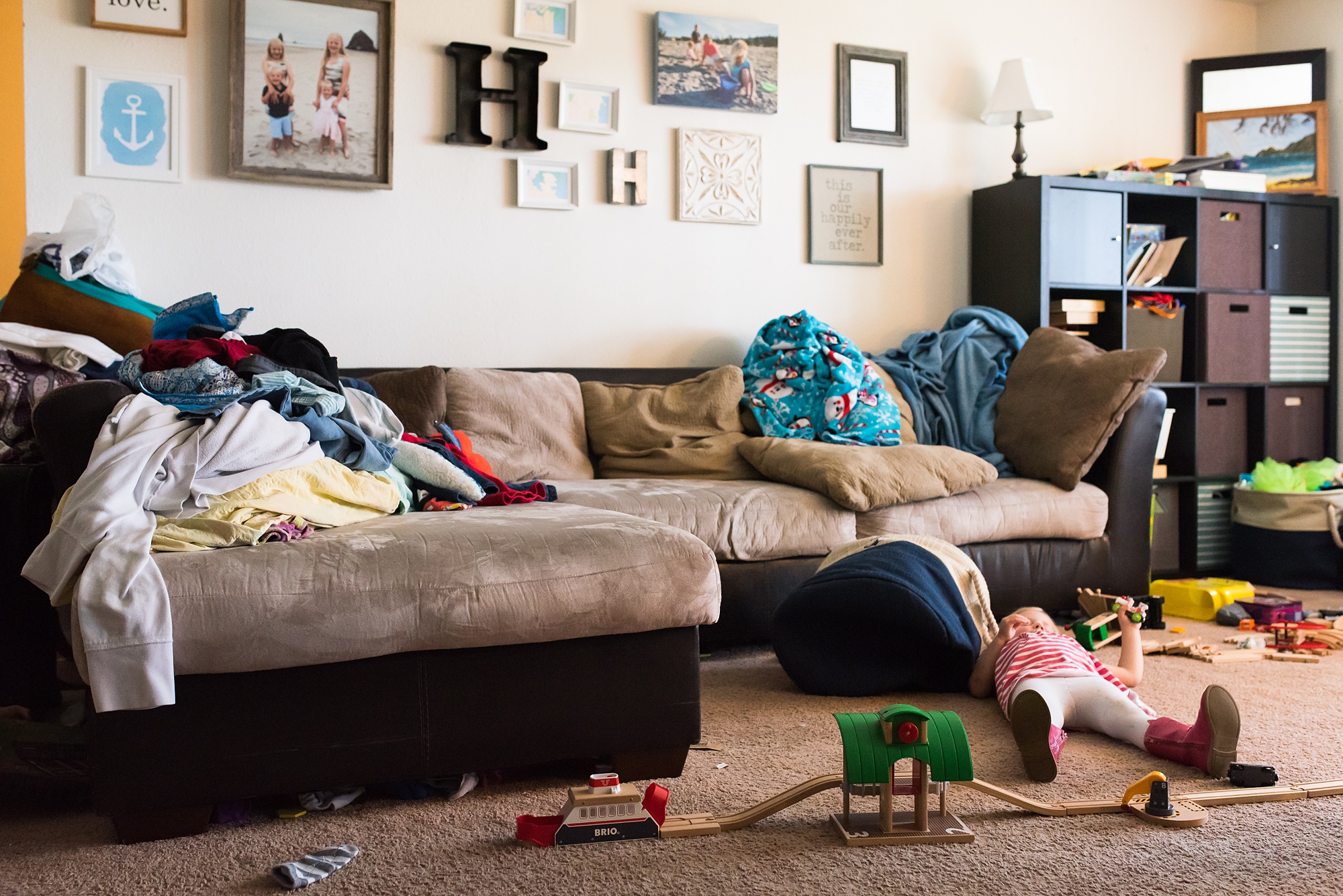 young girl lies on floor amidst mess - military family photography
