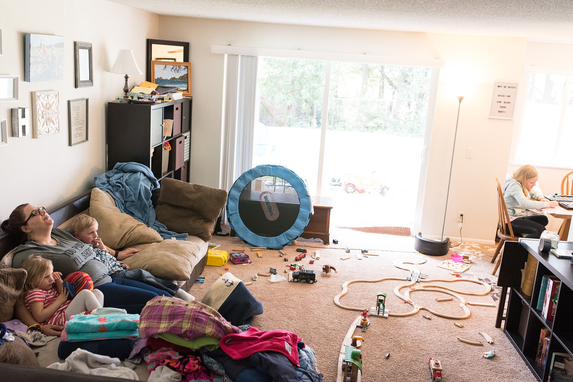 mom dozes on couch surrounded by clutter - military family photography