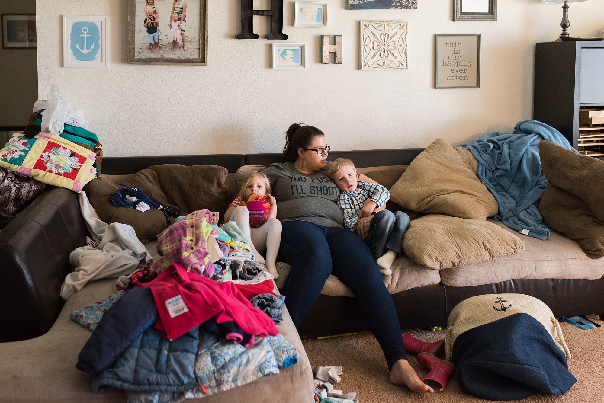 mom snuggles with young kids on couch - military family photography