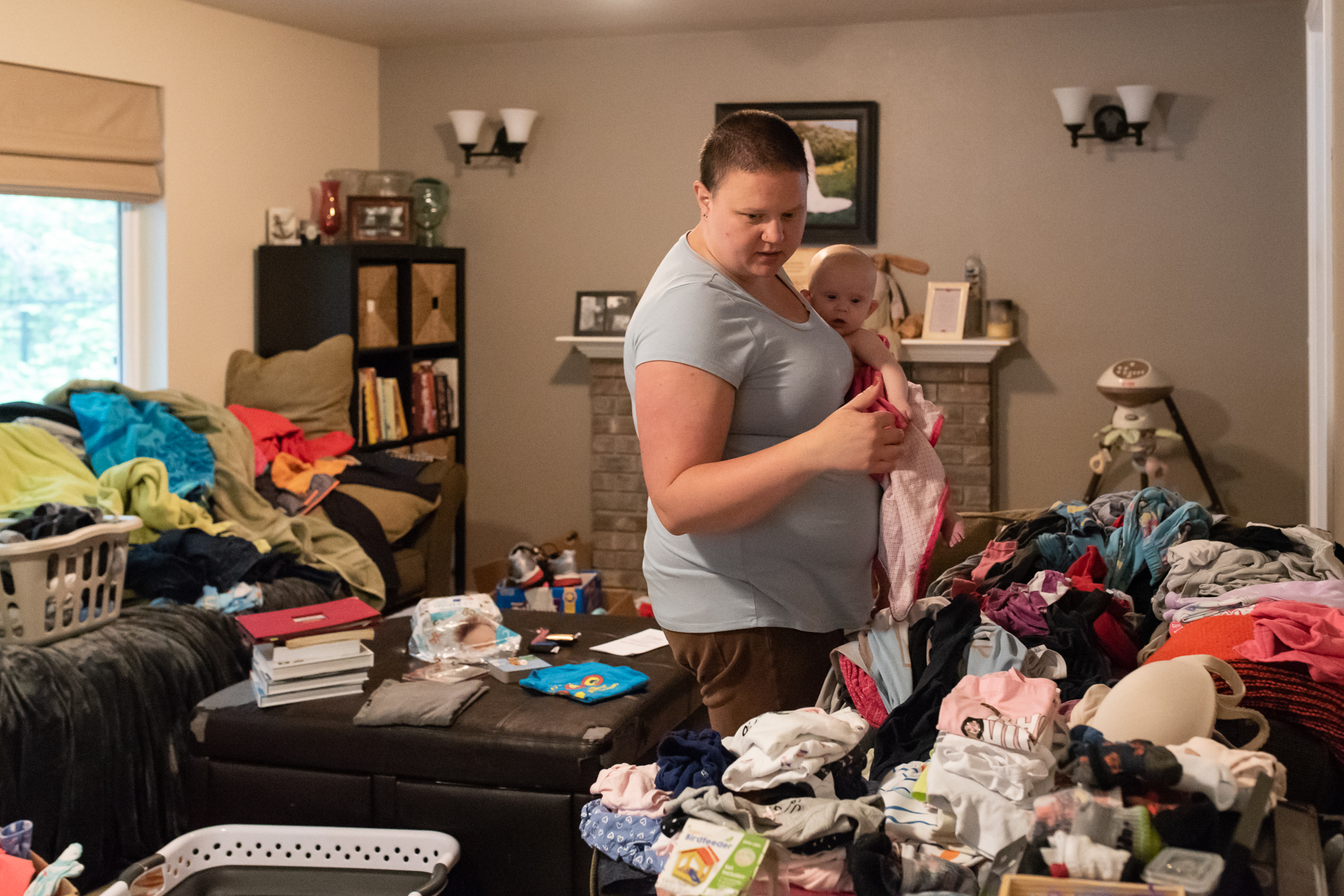 mom searches for baby clothes in piles of laundry