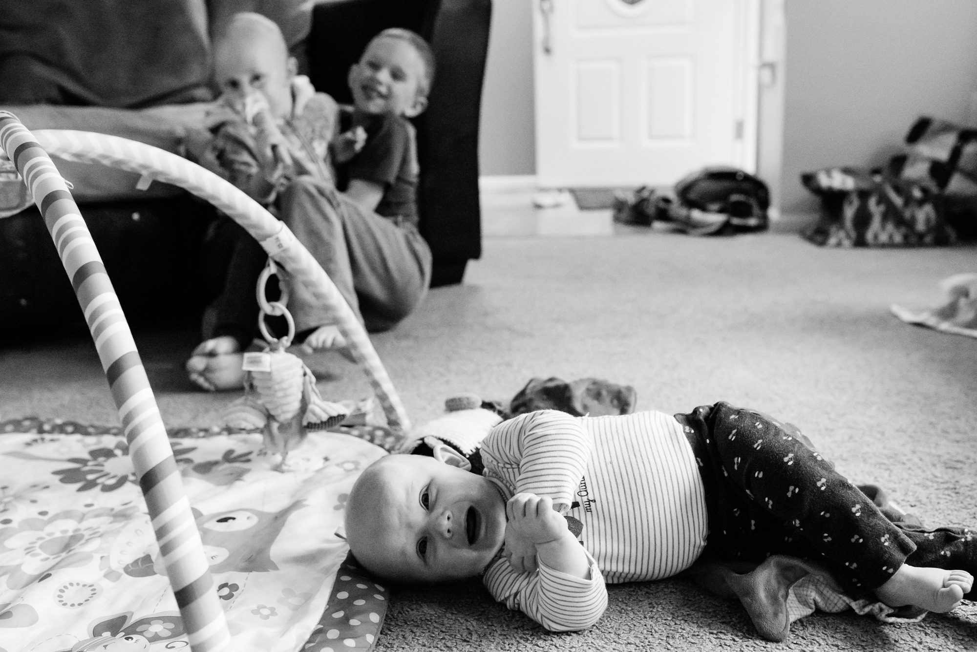 baby cries while siblings wrestle