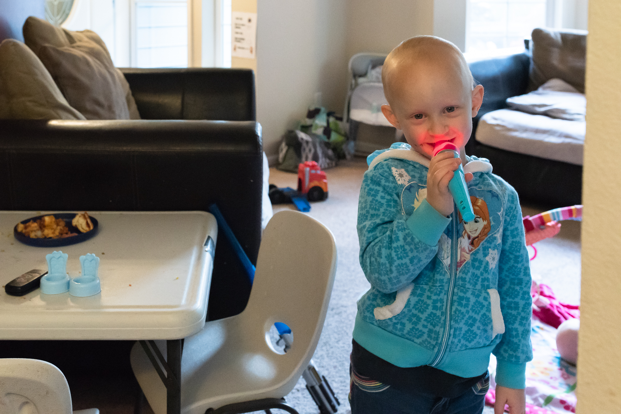 girl sings into toy microphone